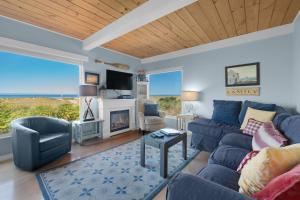a living room with a blue couch and a fireplace at The Tides by the Sea in Seaside