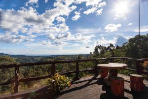 a table on a wooden deck with a view of the mountains at Las Margaritas Salento in Salento