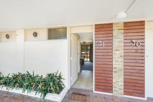 a pivot door in a home with a wooden wall at Tween Waters Merimbula in Merimbula