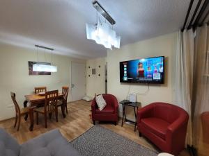 a living room with a table and a tv on the wall at Atacama Valley 6 in Copiapó