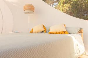 een wit bed met twee kussens erop bij La Bolla di Mag in Saponara Villafranca