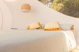 a white bed with two pillows on top of it at La Bolla di Mag in Saponara Villafranca