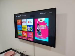 ein Flachbildfernseher, der an einer Wand hängt in der Unterkunft Apartamento Curitiba Palace in Curitiba