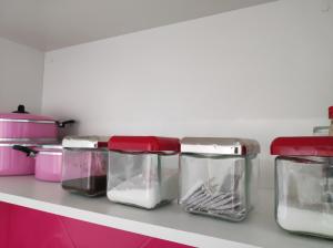 ein Regal mit vier Glasbehältern auf einer Küchentheke in der Unterkunft Apartamento Curitiba Palace in Curitiba + 86 Fotos