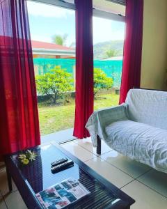 sala de estar con sofá, mesa y ventana en Toa Lodge Bora Bora, en Bora Bora