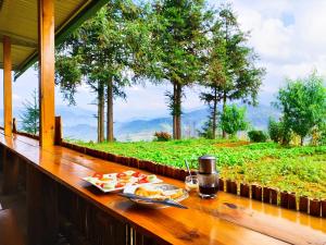 a table with food on it with a view of a field at Mu Cang Chai Homestay & Trekking in Mù Cang Chải