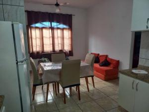 cocina con mesa y sillas y sofá rojo en Casa em Praia Grande -SP, en Praia Grande