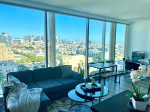 a living room with a couch and a large window at High Rise Studio in Heart of Ktown DTLA in Los Angeles