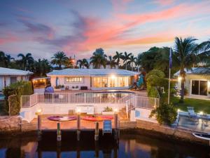 a large house with a dock in the water at Adorable house with Amazing water front of canal in Pompano Beach