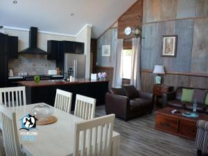 エスペランスにあるA Beautiful New Property, Walking Distance to the Beach in Esperance WA!のキッチン、リビングルーム(テーブル、椅子付)