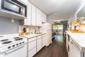 a kitchen with white cabinets and white appliances at Kihei Bay Surf B113 in Kihei