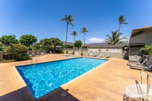 - une piscine dans une cour avec des palmiers dans l'établissement Kihei Bay Surf B113, à Kihei