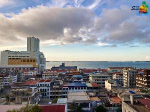 - une vue sur la ville avec ses bâtiments et l'océan dans l'établissement Hotel Sandakan, à Sandakan