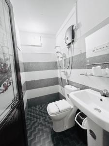 y baño con aseo blanco y lavamanos. en New Peacock Resort en Dambulla