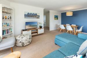 a living room with a blue couch and a table at Heritage 303 in Tuncurry
