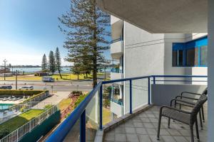 a balcony with a chair and a view of a street at Heritage 303 in Tuncurry