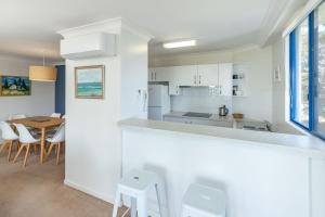 a kitchen and dining room with a table and chairs at Heritage 303 in Tuncurry