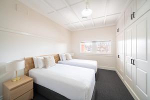 two beds in a bedroom with white walls and a window at Heritage Inn Bathurst in Bathurst +42 photos