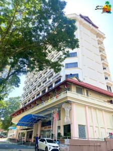 un edificio con un coche aparcado delante de él en Hotel Sandakan en Sandakan