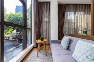 - un salon avec un canapé et une grande fenêtre dans l'établissement Hadiva Boutique Hotel, à Đà Nẵng