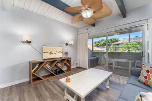 een woonkamer met een plafondventilator en een tafel bij Kihei Bay Surf D142 A Safe Place To Stay in Kihei