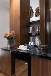 a kitchen with a black counter with flowers on it at Hadiva Boutique Hotel in Da Nang