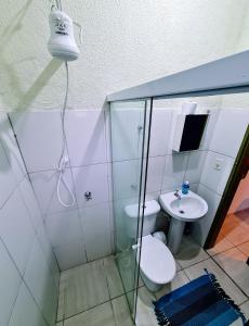 a bathroom with a shower and a toilet and a sink at Praia Suítes Itagua Ubatuba in Ubatuba