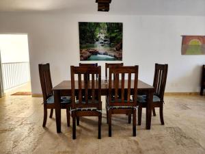a dining room table with chairs and a painting on the wall at Roomy apartment at 5 min walk to the beach in Las Galeras