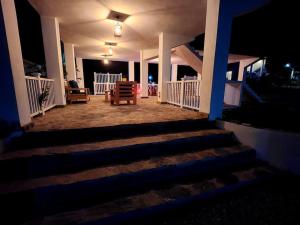 a porch of a house with stairs at night at Roomy apartment at 5 min walk to the beach in Las Galeras
