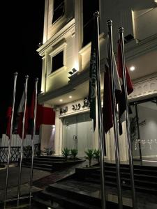 a row of flags in front of a building at night at فندق ياز in Taif