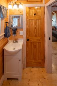 baño con lavabo y puerta de madera en Cherokee Lake Rental en Bean Station