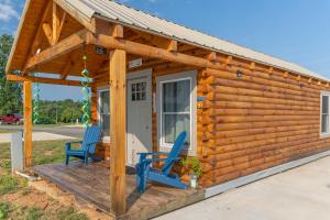 Cabaña de madera con 2 sillas azules en una terraza en Cherokee Lake Rental en Bean Station