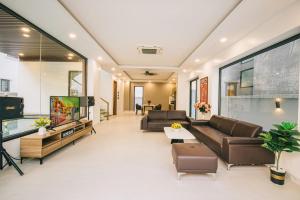 sala de estar con 2 sofás y TV en Sea Villa - FLC Sam Son, en Sầm Sơn