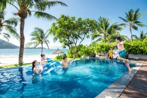 a group of people playing in a swimming pool at a resort at Vinpearl Resort Nha Trang in Nha Trang