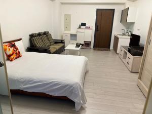 1 dormitorio con 1 cama y sala de estar en 晨曦溫泉宅 en Toucheng