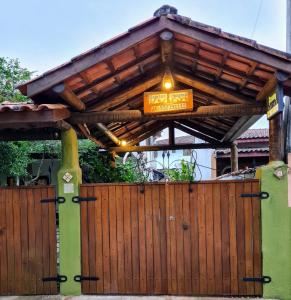 a wooden gate with a sign on top of it at Praia Suítes Itagua Ubatuba in Ubatuba