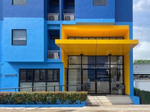un edificio azul y amarillo con puerta de cristal en Hop Inn Udonthani en Udon Thani
