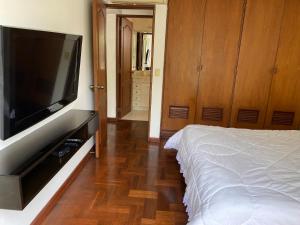 La Molina的住宿－La Molina! Excelente ubicación，一间卧室配有一张床和一台平面电视