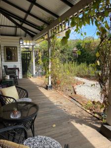 un patio con mesas y sillas en un porche en Wingham House, en Wingham