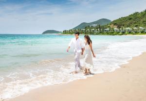ニャチャンにあるVinpearl Resort Nha Trangの海岸を歩く男女