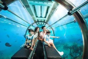 une famille voyageant à bord d'un rouleau compresseur sous-marin à l'aquarium dans l'établissement Vinpearl Resort Nha Trang, à Nha Trang