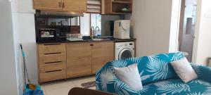 a living room with a blue couch and a kitchen at Timurbay seafront residence in Kuantan
