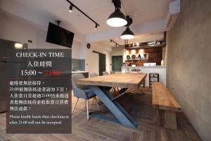 una sala da pranzo con tavolo in legno e una cucina di G.O.A.T Hostel a Città di Hualien