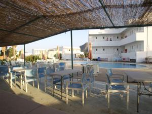a group of tables and chairs next to a swimming pool at Antonis Hotel in Kefalos
