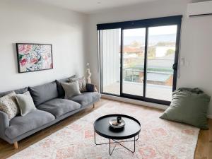 a living room with a couch and a table at Sunny Beachside Home in Orewa