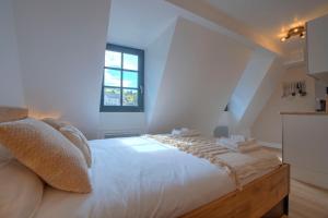 a bedroom with a large white bed with a window at Le Rustique - Netflix/Wi-fi Fibre - Séjour Lozère in Mende