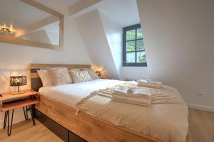 - une chambre avec un grand lit en bois et un miroir dans l'établissement Le Rustique - Netflix/Wi-fi Fibre - Séjour Lozère, à Mende