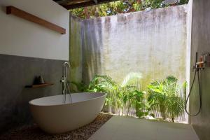 a bathroom with a bath tub in front of a window at ISLAND CENTER POINT in Koh Rong Sanloem