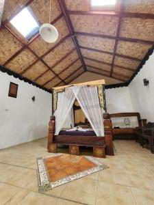 - une chambre avec un lit dans une pièce dotée d'un plafond dans l'établissement Jungle Inn Bukit lawang, à Bukit Lawang