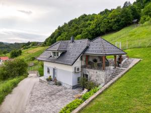 uma casa branca com um telhado de ardósia numa colina em Holiday home in Smarjeske Toplice - Kranjska Krain 45723 em Smarjeske Toplice